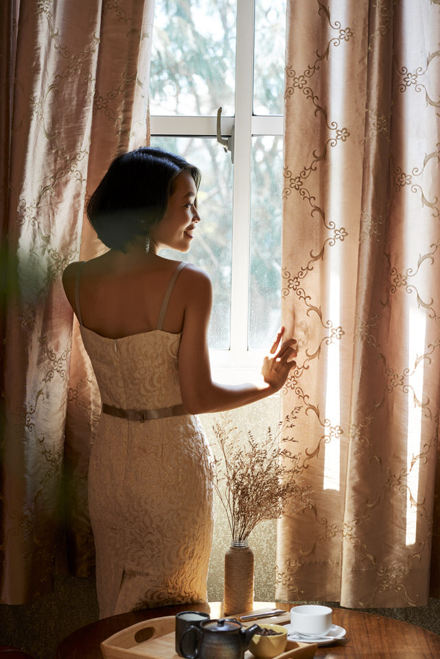 Beautiful Woman Opening Curtains